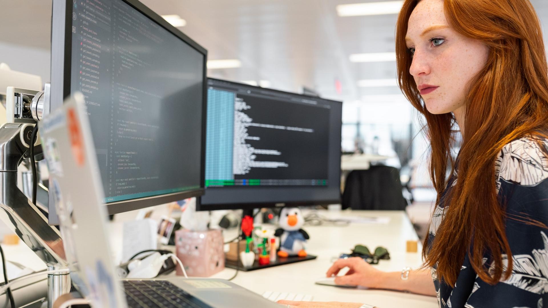 woman in green shirt sitting in front of computer